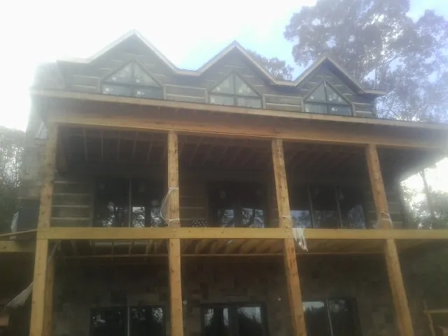 Dormers and porch framing on a large log home under construction — Roof Coating work by our crew in Milpitas