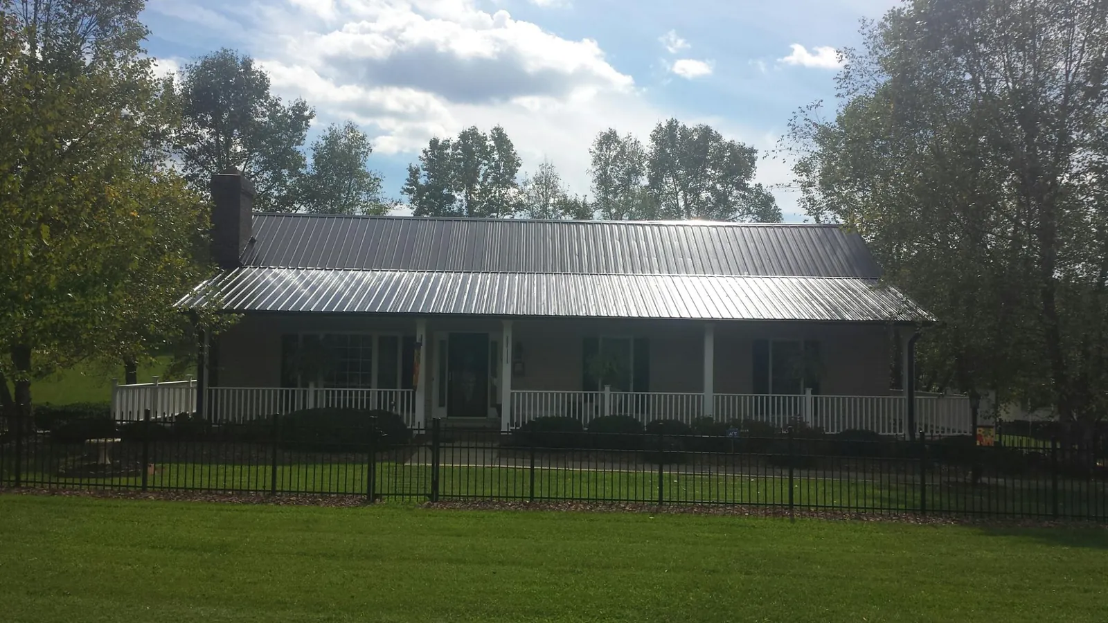 Gray metal roof on a brick ranch with a full width front porch — Gutter Guard Installation work by our crew in Milpitas